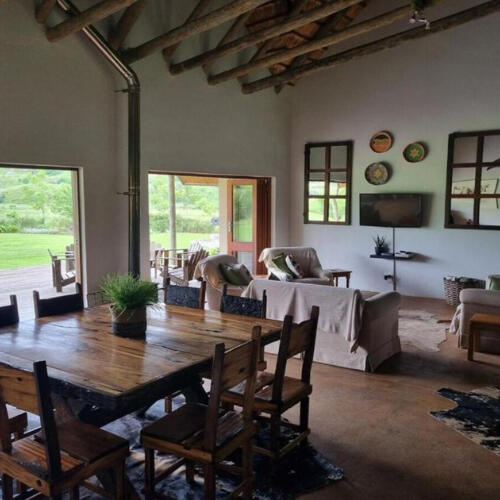 Farm-Style Dining Room at Plain Champagne Rustic dining room at Plain Champagne Guest Farm with wooden table, exposed beams, and open-plan living space