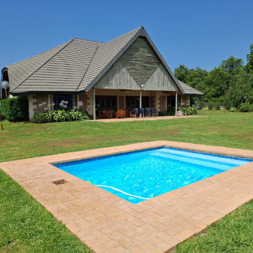 Plain Champagne Pool and Homestead at the Guest Farm Plain Champagne Guest Farm homestead with swimming pool and lawn on a clear day